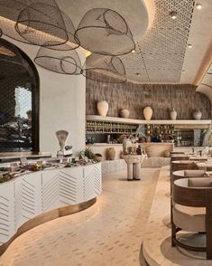 the interior of a restaurant with tables, chairs and food on display at the counter