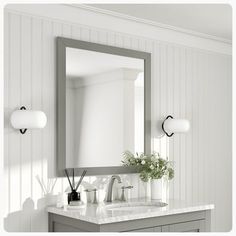 a bathroom vanity with a large mirror and two lights on the wall next to it