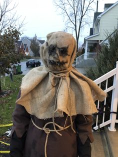 an old scarecrow is standing on the sidewalk