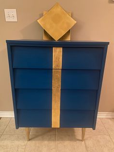 a blue and gold dresser in a room