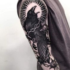 a man with a black crow tattoo on his arm