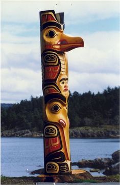 a totema statue in front of a body of water