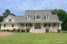 a large white house sitting on top of a lush green field