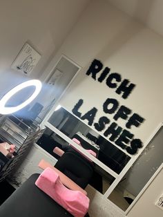 a room that has some black and pink furniture in it with the words rich off lashes written on the wall