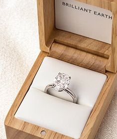 an engagement ring sits in a wooden box