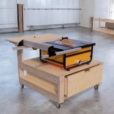 a table sawing on top of a piece of plywood in a garage with two benches behind it