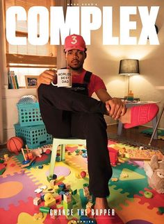 a man sitting on top of a colorful rug holding a coffee mug in his hand