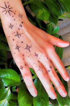 a woman's hand with stars tattooed on it