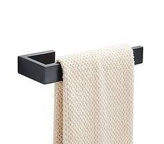 a white towel hanging on the wall next to a black square holder with two towels