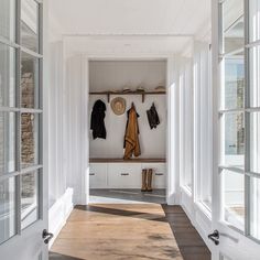 a hallway with white walls and wooden floors