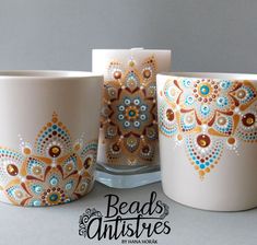 three coffee mugs with designs painted on them