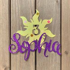 a purple and green sign that says sparkle on it's side next to a wooden fence