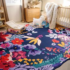 a baby's room with a flowered rug and rocking chair