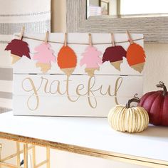 a wooden sign that says grateful next to some pumpkins