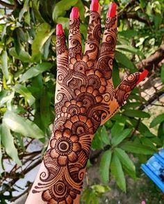 a woman's hand with henna tattoos on it