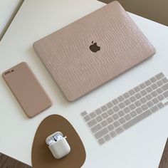 an apple computer, keyboard and mouse on a desk with a pink leather case next to it