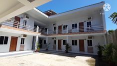 a white house with red shutters and brown doors