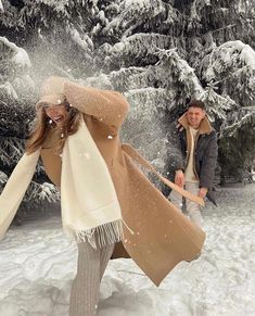 two people walking in the snow with their arms around each other and one person holding a sled