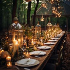 a long table with candles, plates and place settings on it in the middle of a forest