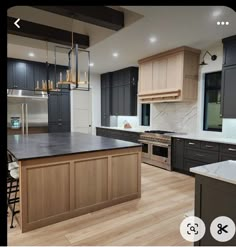 a large kitchen with wooden floors and black cabinets