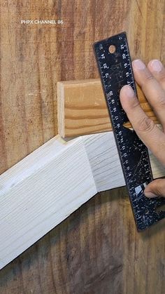 a person using a ruler to measure wood planks