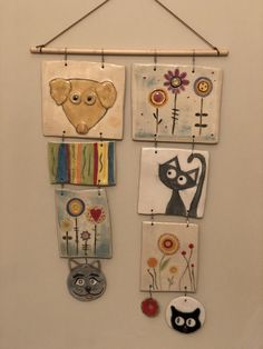 three wall hangings with cats and flowers on them