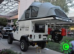 an off road camper is parked on the sidewalk