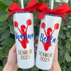 two white tumblers with red bows and the words obama and cheerleader on them