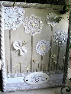 there is a decorative frame with lace and flowers on it, along with other decorations