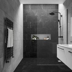 a black and white photo of a bathroom with shower, sink, and towel rack