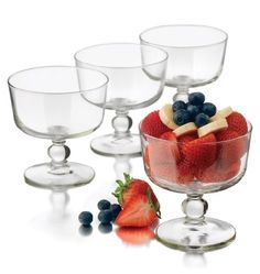 four glasses with strawberries and blueberries in them