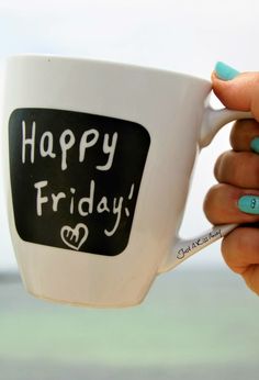 a woman's hand holding a coffee mug with the words happy friday written on it