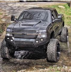 a black truck driving down a muddy road