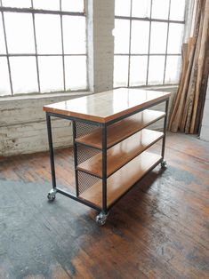 a wooden table sitting on top of a hard wood floor next to a large window