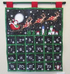 a calendar with santa's sleigh and reindeers on it hanging from the wall