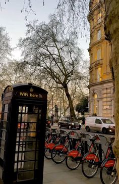 there are many bikes parked next to the telephone booth