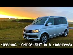 a silver van parked on top of a lush green field next to the ocean with text reading sleeping comfortably in a campervan