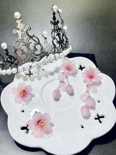 a white plate topped with pink flowers and a crown