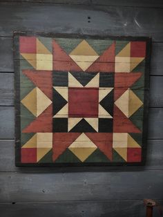 a wooden wall hanging with a colorful quilt on it