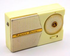 an old yellow radio sitting on top of a white table