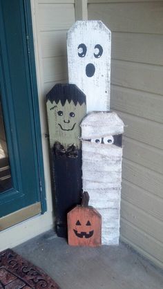 two halloween decorations are sitting on the front porch