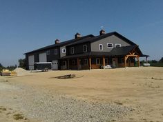 a large gray house sitting on top of a dirt field