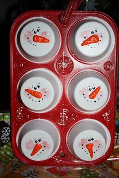 a red tray with four bowls and two snowmen faces