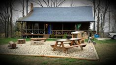 a log cabin with picnic tables in front of it