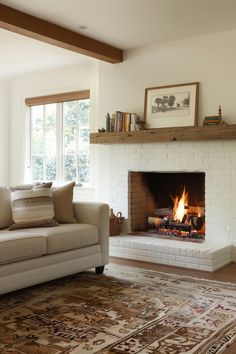 a living room with a fire place in the center and rug on the floor next to it