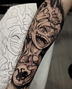 a man's arm with tattoos on it and an image of a demon in the middle