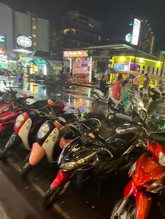 many motorcycles are parked on the street at night