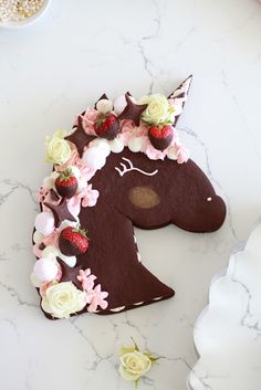 a cake shaped like a horse with flowers on it's head is sitting on a table