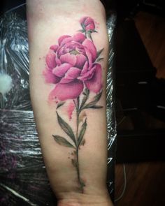 a pink flower tattoo on the arm