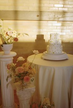 two white vases filled with flowers on top of a table